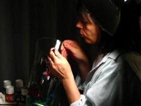 A picture of artist Alison Carol Blackburn painting a crystal vase